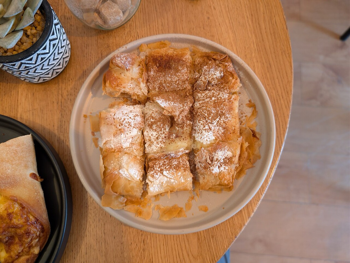 Fresh bougatsa pastry with vanilla custard, dusted with icing sugar and cinnamon