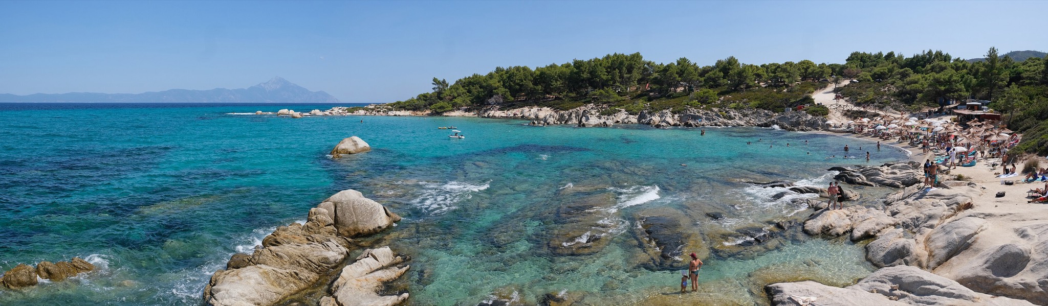 Wide panorama of Kavourotrypes beach in Halkidiki: white rocks, pines and turquoise sea